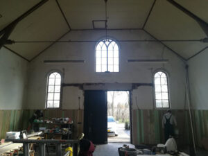 De lambrisering in de kerk wordt geschuurd